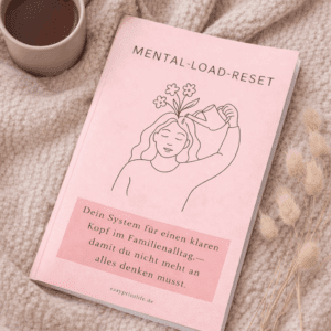 Mental Load Reset Workbook als Heft, cozy drapiert neben einer Tasse Tee auf weichem Stoff – System für einen klaren Kopf im Familienalltag